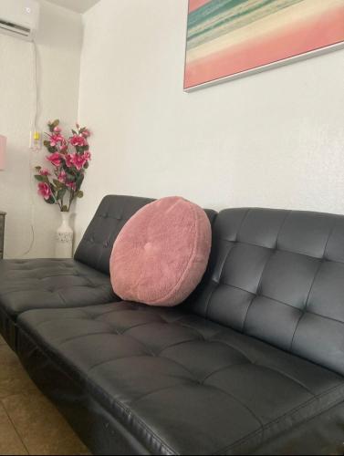 a black leather couch with a pink pillow on it at Cozy Studio - Apt 1 - Private Entrance in Las Vegas