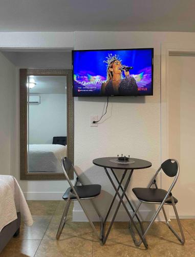 Cozy Studio…With Private Entrance في لاس فيغاس: غرفة مع طاولة وتلفزيون على الحائط