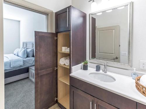 1 dormitorio con 1 cama y baño con lavabo. en Elegant 2BR Ideal for Long Term Stay en Houston