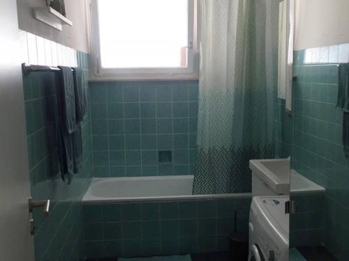 a bathroom with a green tiled tub and a sink at 22C große Wohnung 4 Schlafzimmer Wlan/SmartTV in Korb