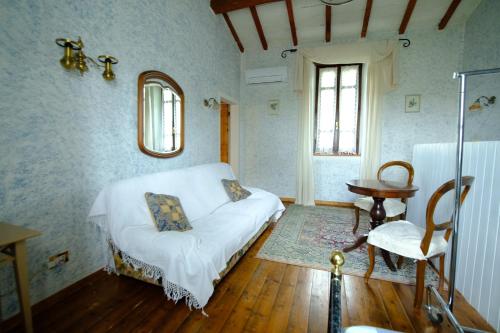 ペスキエーラ・デル・ガルダにあるDimora dei Baccoliのベッド1台、椅子、テーブルが備わる客室です。