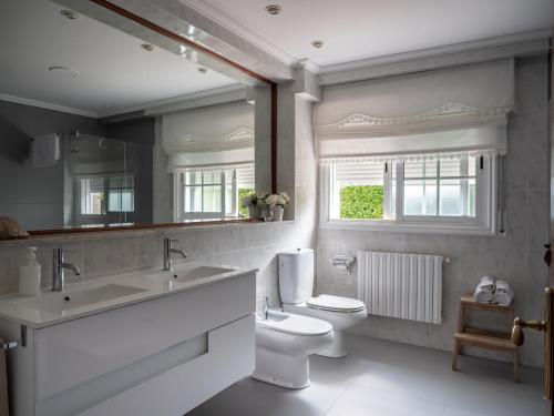 bagno con servizi igienici, lavandino e specchio di Casa Ramos a Vigo