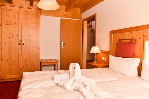 een slaapkamer met een bed met handdoekdieren erop bij Aparthotel Sonnenburg in Schluchsee