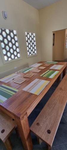 a large wooden table in a room with windows at Easy Breezy in Blanchisseuse
