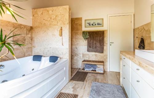 een badkamer met een groot wit bad en een wastafel bij Beautiful Home In Sjllands Odde With Kitchen in Yderby