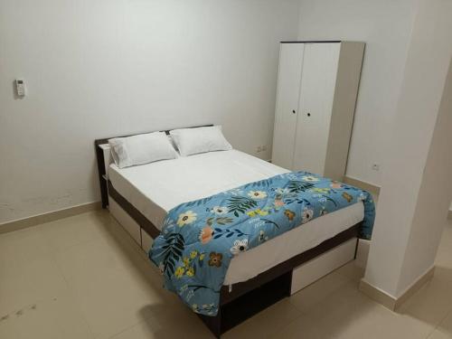 Appartement Yoff Virage vue panoramique sur mer في داكار: غرفة نوم مع سرير وبطانية زرقاء