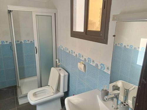 a bathroom with a toilet and a sink and a mirror at Appartement Yoff Virage vue panoramique sur mer in Dakar