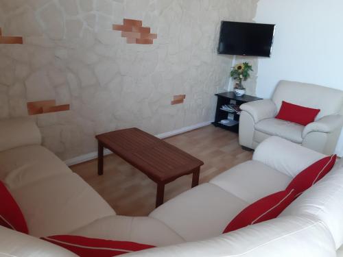 uma sala de estar com dois sofás brancos e uma mesa em Vacances à la Tranche sur Mer em La Tranche-sur-Mer