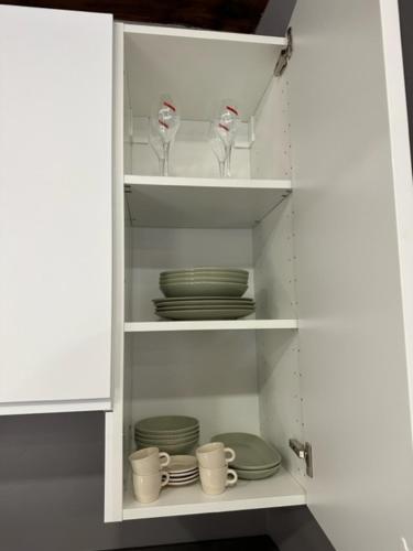 a white cabinet with plates and cups and dishes at City Fun in Rovigo