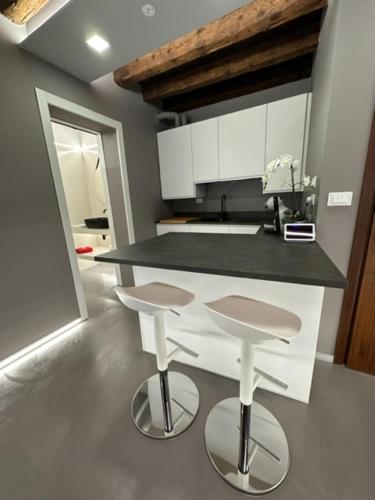 a kitchen with a counter and two stools in it at City Fun in Rovigo