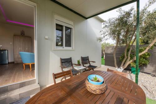 a patio with a wooden table and chairs at The Home Away from Home with Hot Tub in Lampi