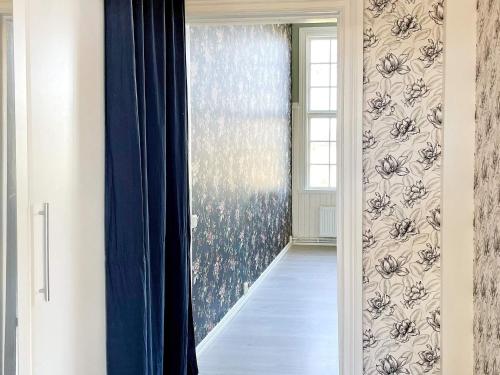 a hallway with a blue curtain and a window at 9 person holiday home in Mörlunda-By Traum in Mörlunda