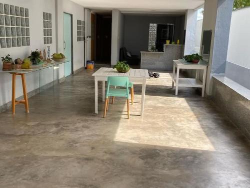 a kitchen with a table and a blue chair at Ed Bertholi - Vista lateral do mar com garagem in Serra