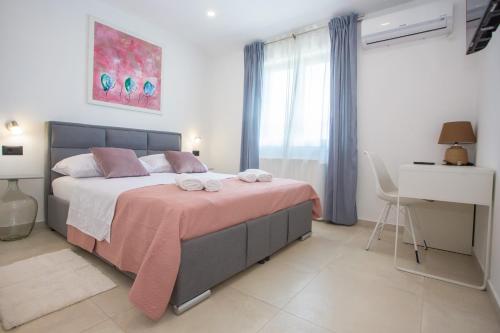 1 dormitorio con 1 cama grande con manta rosa en Villa Silvano & Nadija, en Kaštelir