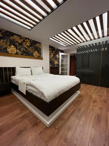 een slaapkamer met een groot bed met witte lakens bij BLACKLAKE OTEL in Yeniyol