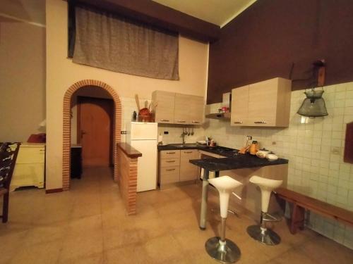 a kitchen with white cabinets and a black counter top at Loft, Il Giardino Sabino in Palombara Sabina