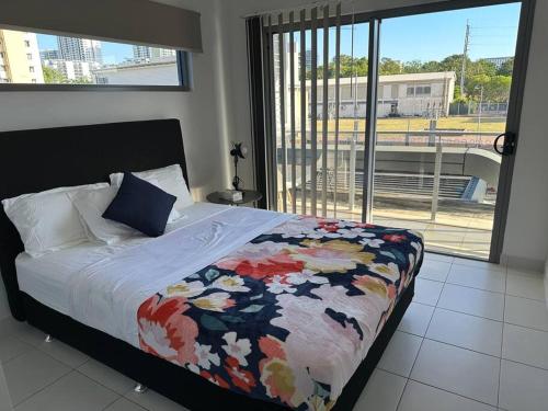 Un dormitorio con una cama con una colcha colorida. en Lovely 3 Bedroom Condo with Pool en Darwin