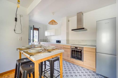une cuisine avec une table en bois et un réfrigérateur dans l'établissement BEAU T3 Clim grand balcon plage calanques Vieux Port, à Marseille