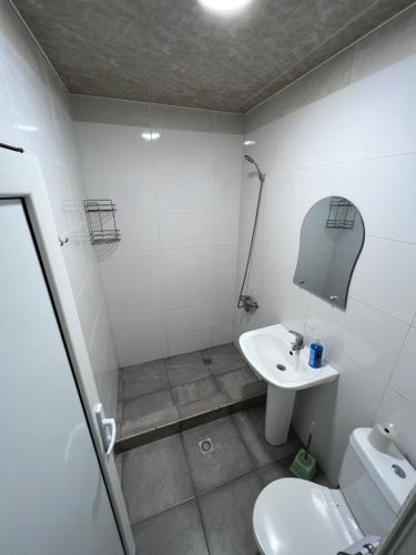 a bathroom with a white toilet and a sink at GVALA in Vardzia