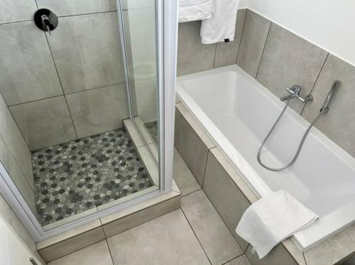 a bathroom with a shower with a glass door at Sophiscated Upmarket One Bedroom Apartment in Johannesburg