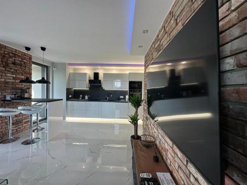 a kitchen and living room with a brick wall at Apartament Centrum II in Bydgoszcz