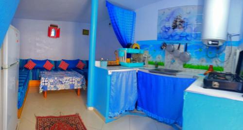 a blue room with a kitchen with a sink and a refrigerator at The blue in Chefchaouen