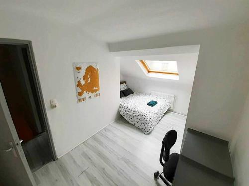 une petite pièce avec un lit et une chaise dans l'établissement Duplex à deux pas de la place Stanislas, à Nancy