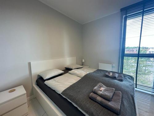 een slaapkamer met een groot bed en 2 handdoeken bij Apartament Centrum II in Bydgoszcz