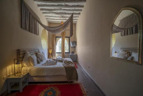 a bedroom with a bed and a large mirror at Taj Atlas Wellness Boutique Hôtel & Spa in Amizmiz