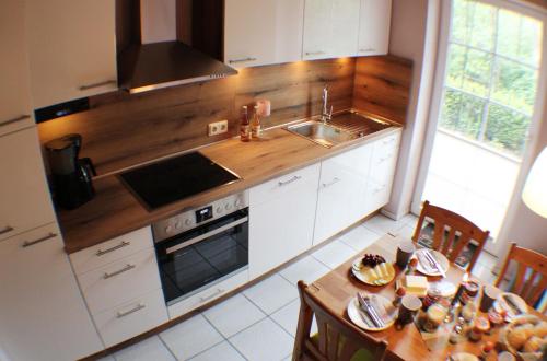 une cuisine avec des placards blancs et un comptoir en bois dans l'établissement Ferienwohnung Lüneburger Heide, à Schneverdingen