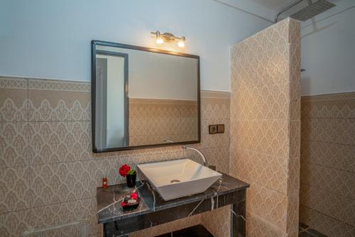 a bathroom with a sink and a mirror at Taj Atlas Wellness Boutique Hôtel & Spa in Amizmiz