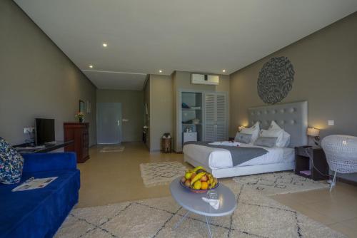 a bedroom with a bed and a blue couch at Taj Atlas Wellness Boutique Hôtel & Spa in Amizmiz