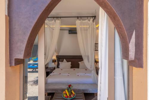 a bedroom with a bed with a canopy at Taj Atlas Wellness Boutique Hôtel & Spa in Amizmiz