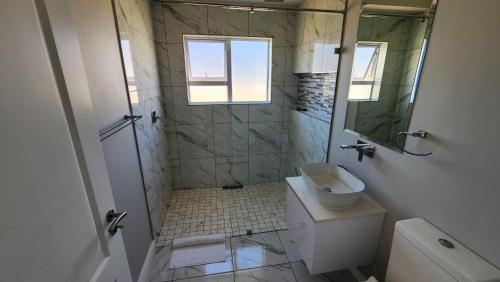 uma casa de banho com um chuveiro, um WC e um lavatório. em One Bedroom Unit with Kitchenette in Langebaan Country Estate - Solar Power em Langebaan