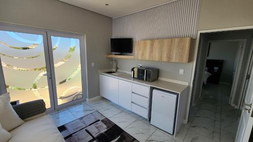 a kitchen with a counter and a microwave in a room at One Bedroom Unit with Kitchenette in Langebaan Country Estate - Solar Power in Langebaan