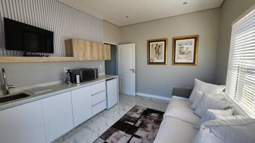 a living room with a couch and a kitchen at One Bedroom Unit with Kitchenette in Langebaan Country Estate - Solar Power in Langebaan