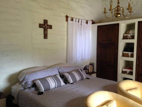 um quarto com uma cama com uma cruz na parede em Hermosa Casa Tipica en Malinalco em Malinalco