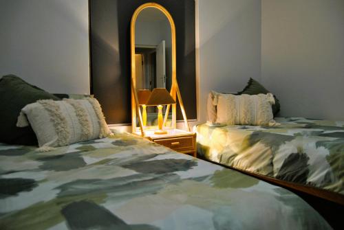 a bedroom with two beds and a mirror at 201 Hexrivier in Hartenbos