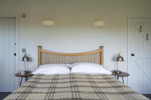 1 dormitorio con 1 cama con 2 lámparas en las mesas en The Threshing Barn, en Loddiswell