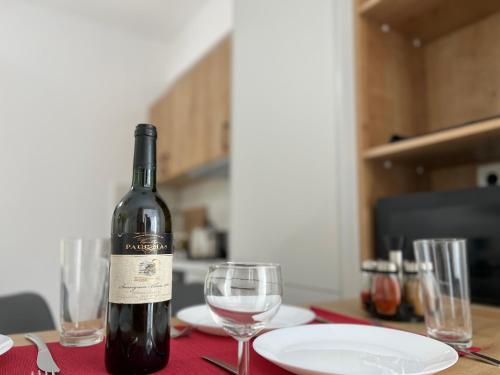 a bottle of wine sitting on a table with glasses at 3 Bedroom House included free car rental in Perissa