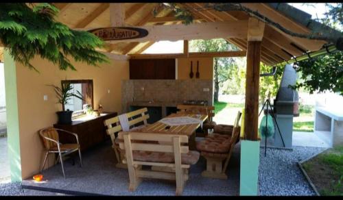 a wooden table and chairs under a pergola at SUN RIVER KOLPA Ap2 in Vinica