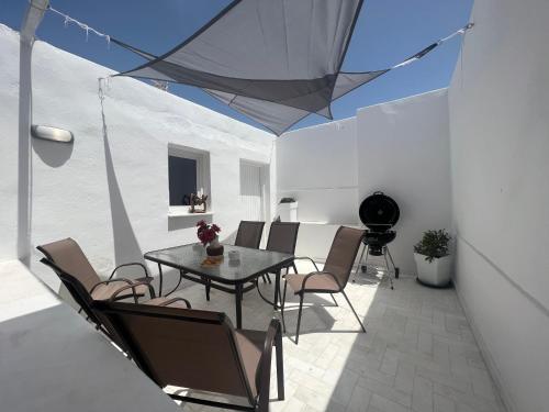 a patio with a table and chairs in a room at 3 Bedroom House included free car rental in Perissa