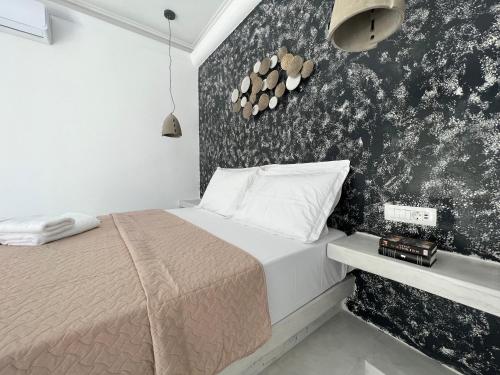 a bedroom with a bed and a black and white wall at 3 Bedroom House included free car rental in Perissa