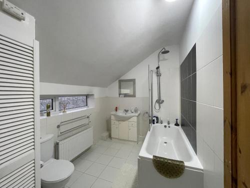 uma casa de banho branca com uma banheira e um lavatório em SOUTH COAST ROOM WITH PARKING SPACE NEAR THE BEACh em Poole