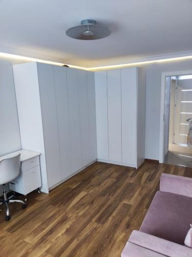 Pokój z białymi ścianami, biurkiem i łóżkiem w obiekcie Apartament Frombork we Fromborku