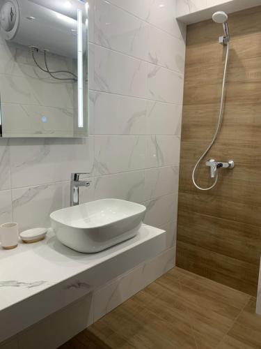 a white bathroom with a sink and a shower at Park and pool studios in Nesebar