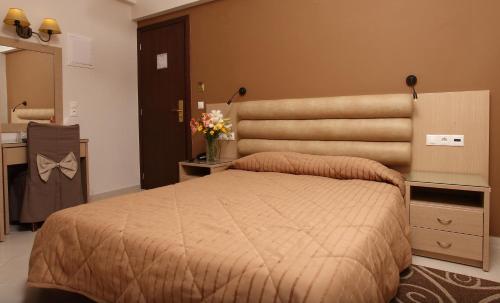 a bedroom with a large bed with a large headboard at Kronos Hotel in Heraklio Town