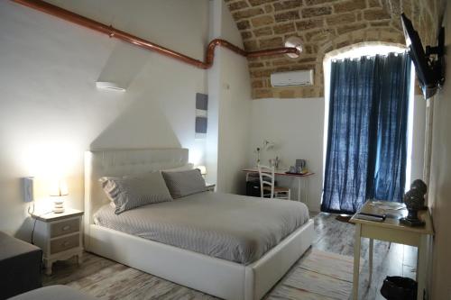 1 dormitorio con cama blanca y ventana en B&B Il Grifone, en Gioia del Colle