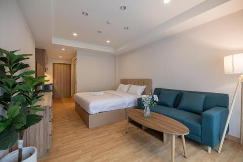 a hotel room with a bed and a blue couch at Exoresidence The Heart of Chinatown in Bangkok