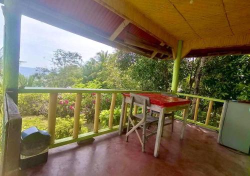 a porch with a table and chairs on a balcony at La Villa Alta in Siquijor